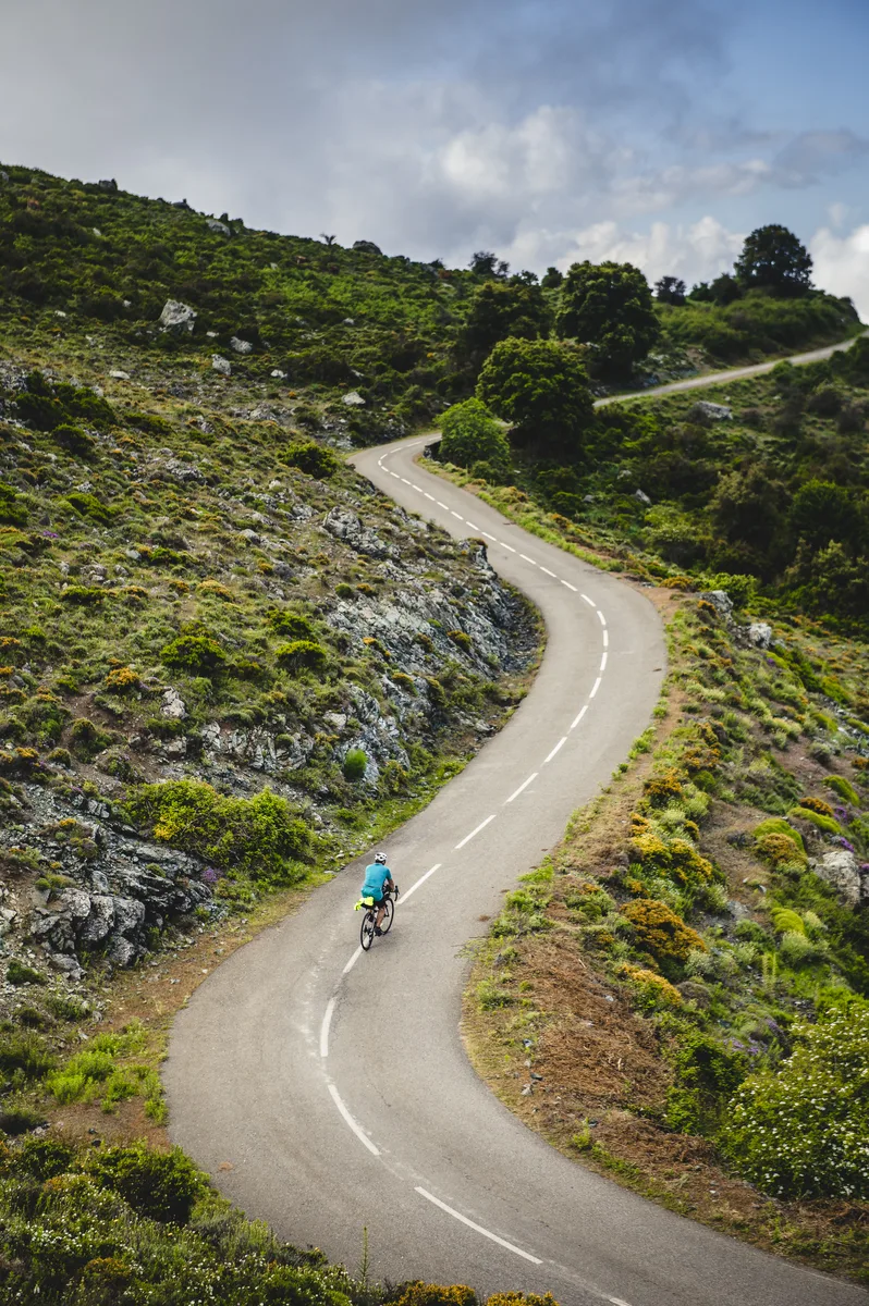 A cyclist riding a winding mountain road